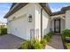 Exterior view of the home featuring the garage, front entry, beautiful landscaping, and paved walkway at 16226 Hidden Oak Loop, Lakewood Ranch, FL 34211