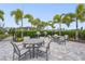 A covered grilling area with tables, chairs, and palm trees at 16226 Hidden Oak Loop, Bradenton, FL 34211