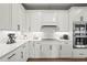 Close-up view of the kitchen with pristine white cabinets, granite countertops, and stainless steel appliances at 16226 Hidden Oak Loop, Lakewood Ranch, FL 34211