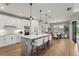 Modern kitchen features a large island, white cabinetry, stainless steel appliances, and an adjacent dining area with natural light at 16226 Hidden Oak Loop, Lakewood Ranch, FL 34211