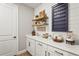 This laundry room boasts ample white cabinetry, floating shelves, and a modern farmhouse design at 16226 Hidden Oak Loop, Lakewood Ranch, FL 34211