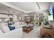 Bright living room featuring a large sofa, modern decor, and seamless access to outdoor living through sliding glass doors at 16226 Hidden Oak Loop, Lakewood Ranch, FL 34211