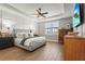 Serene main bedroom with tray ceiling, paneled accent wall, hardwood floors, and ample natural light at 16226 Hidden Oak Loop, Lakewood Ranch, FL 34211