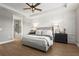 Serene main bedroom featuring a decorative panel wall, tray ceiling, and access to an ensuite bathroom with tub at 16226 Hidden Oak Loop, Bradenton, FL 34211