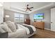 Relaxing main bedroom showcases an accent dresser, large window, and a view of a flat screen TV on the wall at 16226 Hidden Oak Loop, Lakewood Ranch, FL 34211