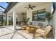 The covered patio boasts a seating area with a ceiling fan and outdoor furniture at 16226 Hidden Oak Loop, Lakewood Ranch, FL 34211