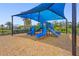 A colorful playground featuring slides and climbing structures under a blue sunshade, perfect for outdoor activities at 16226 Hidden Oak Loop, Lakewood Ranch, FL 34211