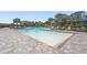A dazzling, resort-style zero entry pool with plenty of lounge seating and lush tropical landscaping at 16226 Hidden Oak Loop, Lakewood Ranch, FL 34211