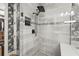 Modern tiled shower featuring a rainfall showerhead and decorative accent tiles and a convenient recessed shelf at 16226 Hidden Oak Loop, Lakewood Ranch, FL 34211