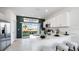 Modern kitchen with stainless steel appliances, white cabinets, breakfast bar and sliding door to the backyard at 16554 San Nicola Pl, Lakewood Ranch, FL 34211