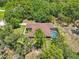 Aerial view of a single Gathering house with a screened in pool surrounded by trees and landscaping at 18026 Nutcracker Rd, Weeki Wachee, FL 34614