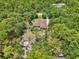 Aerial view of a secluded home with a pool and outdoor seating surrounded by lush trees and greenery at 18026 Nutcracker Rd, Weeki Wachee, FL 34614