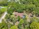 Aerial view of a single Gathering house with a screened in pool surrounded by trees and landscaping at 18026 Nutcracker Rd, Weeki Wachee, FL 34614