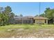 Exterior of home with screened-in lanai and spacious backyard, offering a blend of indoor-outdoor living and serene views at 18026 Nutcracker Rd, Weeki Wachee, FL 34614
