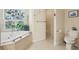 Bathroom with jacuzzi tub, stained-glass window, separate shower, and toilet at 18026 Nutcracker Rd, Weeki Wachee, FL 34614
