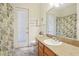 Bright bathroom featuring a granite vanity, tile flooring, and a door to the backyard at 18026 Nutcracker Rd, Weeki Wachee, FL 34614