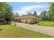 Spacious driveway leading to a two-car garage with a well-maintained exterior and lush landscaping surrounding the property at 18026 Nutcracker Rd, Weeki Wachee, FL 34614