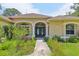 Charming home featuring a welcoming front entrance with beautiful columns and lush landscaping at 18026 Nutcracker Rd, Weeki Wachee, FL 34614