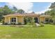 Inviting single-story home featuring a well-manicured lawn, arched windows, and a covered entryway framed by classic columns at 18026 Nutcracker Rd, Weeki Wachee, FL 34614