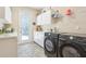 Well-lit laundry room with modern washer and dryer, ample counter space, and convenient exterior access at 18026 Nutcracker Rd, Weeki Wachee, FL 34614