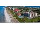 Scenic aerial view of beachside condos, showcasing the community pool, lush landscaping, and proximity to the ocean at 2045 Gulf Of Mexico Dr # 207, Longboat Key, FL 34228