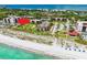 Breathtaking aerial view of beachfront condos with lush landscaping and pristine beach access, perfect for coastal living at 2045 Gulf Of Mexico Dr # M1-207, Longboat Key, FL 34228