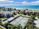 Aerial showcases community tennis courts near beachfront condos for active living at 2045 Gulf Of Mexico Dr # M1-207, Longboat Key, FL 34228