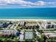 Stunning aerial view of beachfront condos and tennis courts with ocean backdrop at 2045 Gulf Of Mexico Dr # M1-207, Longboat Key, FL 34228