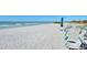 Beautiful beach scene with lounge chairs and a turquoise umbrella, offering a relaxing waterfront experience at 2045 Gulf Of Mexico Dr # M1-207, Longboat Key, FL 34228