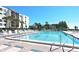 Large community pool area featuring plenty of seating, palm trees, and direct views of the beachfront and nearby condos at 2045 Gulf Of Mexico Dr # M1-207, Longboat Key, FL 34228