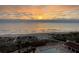 Serene sunrise view overlooking the ocean and pool, providing a picturesque and relaxing scene at 2045 Gulf Of Mexico Dr # 207, Longboat Key, FL 34228