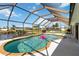 A pristine screened-in pool overlooking a canal, complete with lounge chairs for relaxation at 21152 Higgs Dr, Port Charlotte, FL 33952