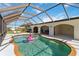 An inviting screened-in pool with a playful flamingo float and a covered outdoor dining area at 21152 Higgs Dr, Port Charlotte, FL 33952