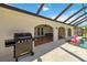 A grilling area is adjacent to a screened-in pool with an outdoor dining space at 21152 Higgs Dr, Port Charlotte, FL 33952
