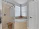 Modern bathroom featuring a corner tub, separate glass shower, and natural light from the window for a bright space at 212 River Enclave Ct, Bradenton, FL 34212