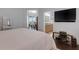 Bright bedroom with a TV, and a view of the ensuite bathroom and the balcony which enhances the overall sense of space at 212 River Enclave Ct, Bradenton, FL 34212