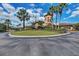 Exterior view of the clubhouse featuring palm trees, flowers, and decorative landscaping at 212 River Enclave Ct, Bradenton, FL 34212