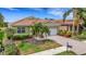 Well-maintained home with a tile roof, manicured landscaping, and a brick driveway at 212 River Enclave Ct, Bradenton, FL 34212