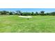 Scenic golf course with a sand trap and mature trees against a clear blue sky at 212 River Enclave Ct, Bradenton, FL 34212