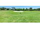Expansive green golf course with a sand trap and mature trees against a clear blue sky at 212 River Enclave Ct, Bradenton, FL 34212