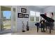 Elegant living area with a grand piano, shuttered windows, and detailed trim at 212 River Enclave Ct, Bradenton, FL 34212