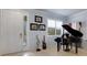 Elegant living area with a grand piano, shuttered windows, and detailed trim at 212 River Enclave Ct, Bradenton, FL 34212