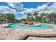 Detailed pool view shows the sunning deck with lounge chairs, mature tropical landscaping, and shallow pool at 212 River Enclave Ct, Bradenton, FL 34212