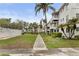 Exterior of residential building with manicured lawns, palm trees, and a pool in the background at 2207 Sunset Dr # E5, Bradenton, FL 34207