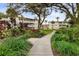 Scenic courtyard with a paved walkway, mature trees, and beautiful landscaping surrounding the residential buildings at 2207 Sunset Dr # E5, Bradenton, FL 34207