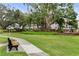 Green lawns, a bench, and mature trees provide a park-like setting for this condo community at 2207 Sunset Dr # E5, Bradenton, FL 34207