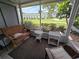 Relaxing screened porch with comfortable wicker furniture and a view of the well-maintained community landscaping at 2207 Sunset Dr # E5, Bradenton, FL 34207