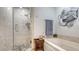 Spa bathroom with a glass shower, pebble floor and soaking tub with lovely art at 235 Cocoanut Ave # 108B, Sarasota, FL 34236