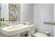 Cozy bathroom with white sink, toilet, towel rack, and a decorative shelving unit filled with figurines at 235 Cocoanut Ave # 108B, Sarasota, FL 34236