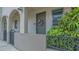 Charming entryway of a condo with a gray door, decorative wreath, and lush greenery at 235 Cocoanut Ave # 108B, Sarasota, FL 34236